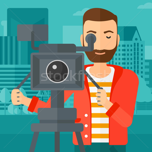 Stock photo: Cameraman with movie camera on a tripod.