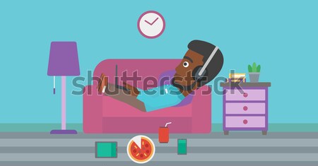 Stock photo: Woman lying on sofa with many gadgets.