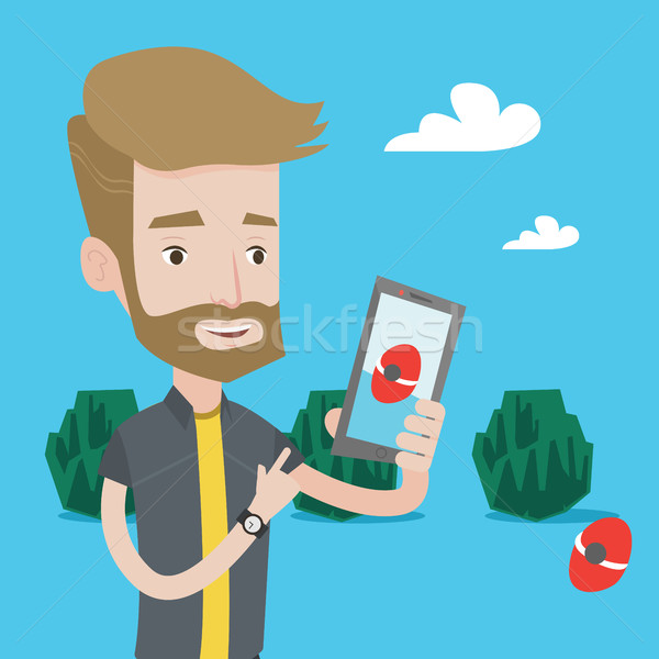 Hipster man with the beard playing action game on smartphone Stock photo © RAStudio