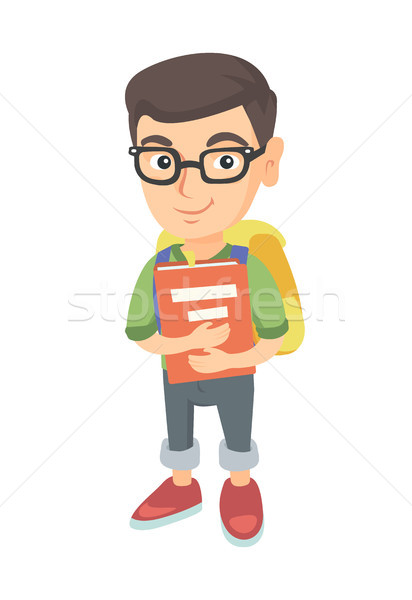 Stock photo: Caucasian schoolboy with backpack and textbook.