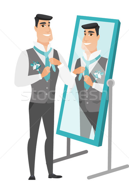 Groom looking in the mirror and adjusting tie. Stock photo © RAStudio