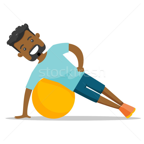 Young african-american man exercising with fitball Stock photo © RAStudio