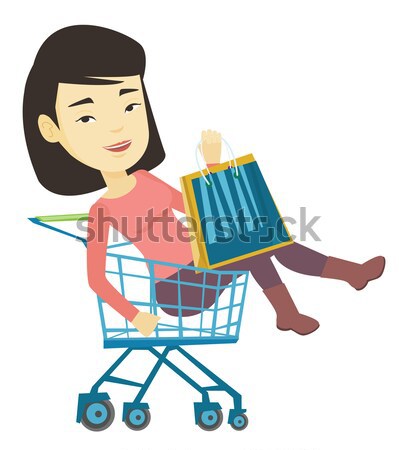 Happy woman riding by shopping trolley. Stock photo © RAStudio