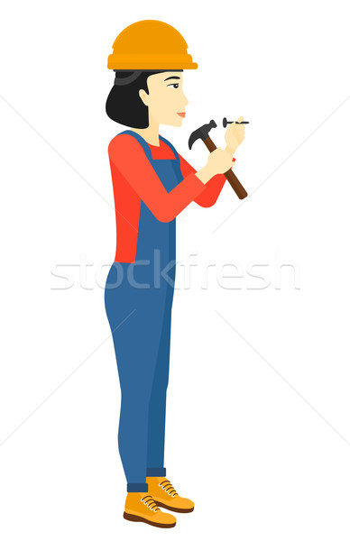 Woman hammering nail. Stock photo © RAStudio