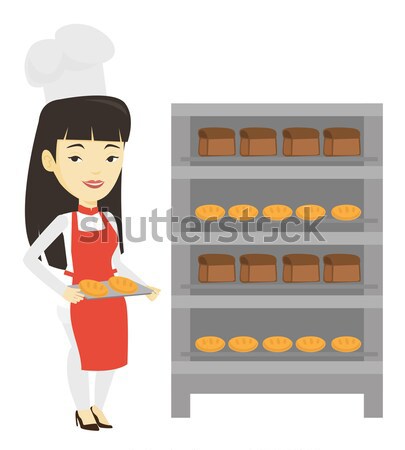 Happy young female baker holding tray of bread. Stock photo © RAStudio