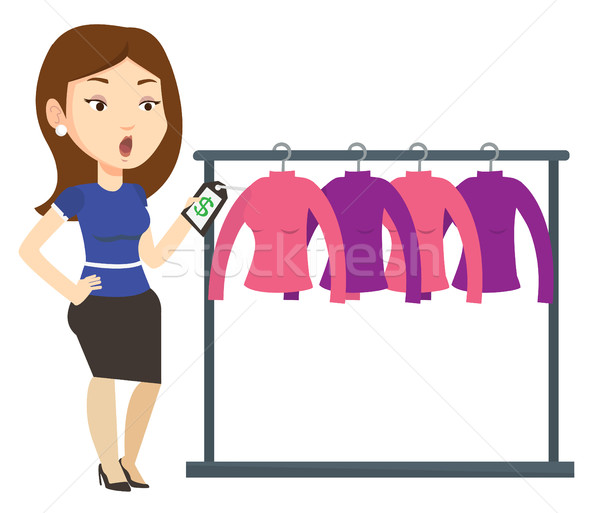 Woman shocked by price tag in clothing store. Stock photo © RAStudio