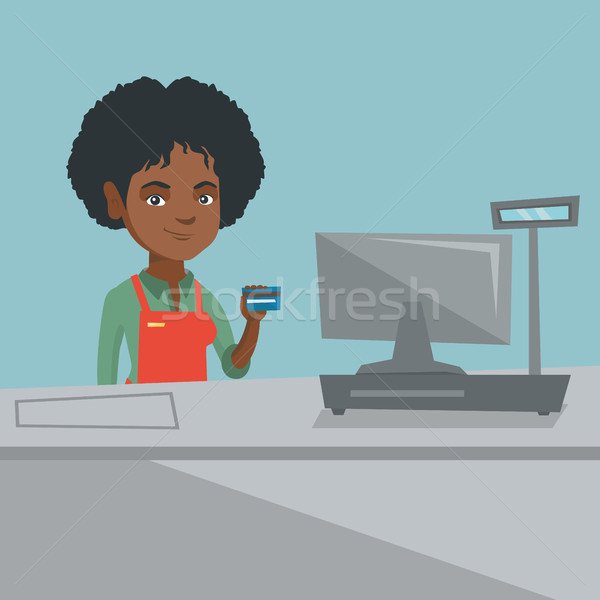 Young african-american cashier holding credit card Stock photo © RAStudio