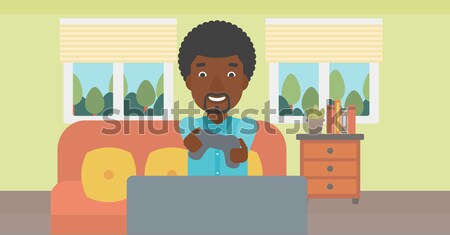 Człowiek gry gra wideo entuzjastyczny posiedzenia sofa Zdjęcia stock © RAStudio