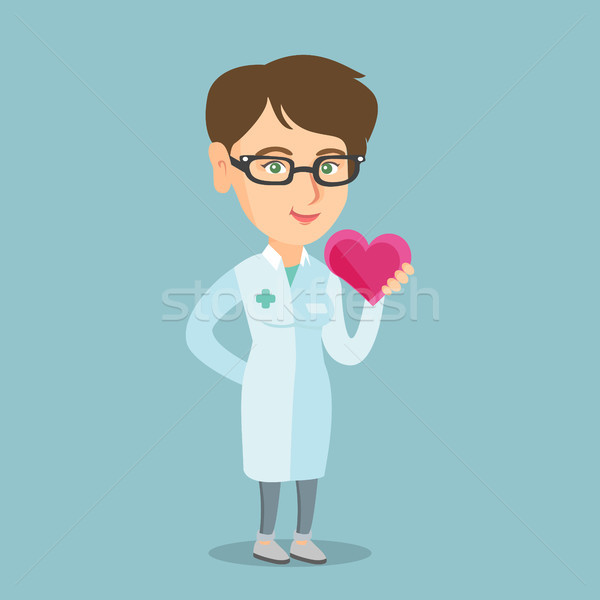 Young caucasian doctor cardiologist holding heart. Stock photo © RAStudio