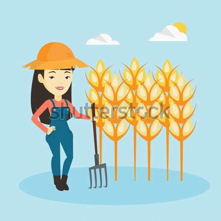 Young farmer standing in a field with pitchfork. Stock photo © RAStudio