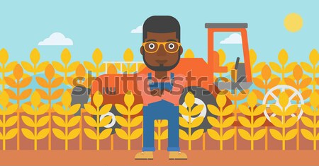 Stock photo: Farmer on the field with scythe.