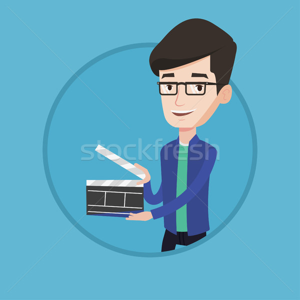 Smiling man holding an open clapperboard. Stock photo © RAStudio