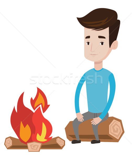 Man sitting on log near campfire. Stock photo © RAStudio