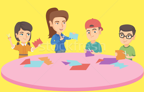 Teacher and children cutting paper with scissors. Stock photo © RAStudio