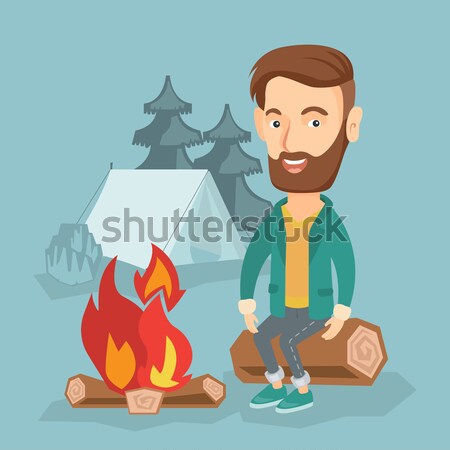 Man sitting on log near campfire in the camping. Stock photo © RAStudio