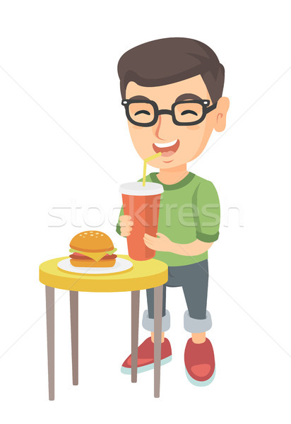 Stock photo: Little boy drinking soda and eating cheeseburger.