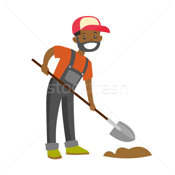Stock photo: A happy black farmer with a shovel on a farm field.