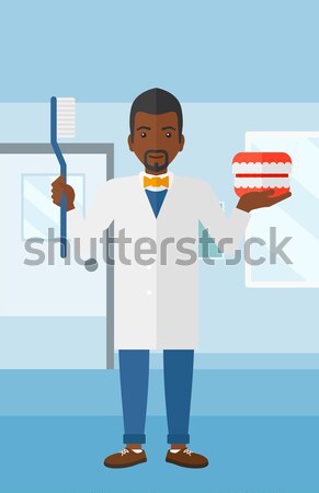 Dentist with dental jaw model and toothbrush. Stock photo © RAStudio
