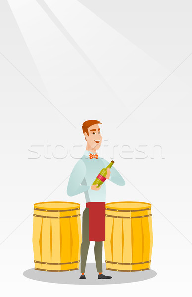 Stock photo: Caucasian waiter holding a bottle of wine.