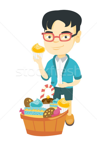 Boy holding a cupcake and stroking his belly. Stock photo © RAStudio