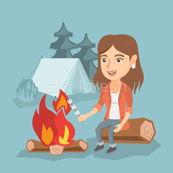 Caucasian girl roasting marshmallow over campfire. Stock photo © RAStudio
