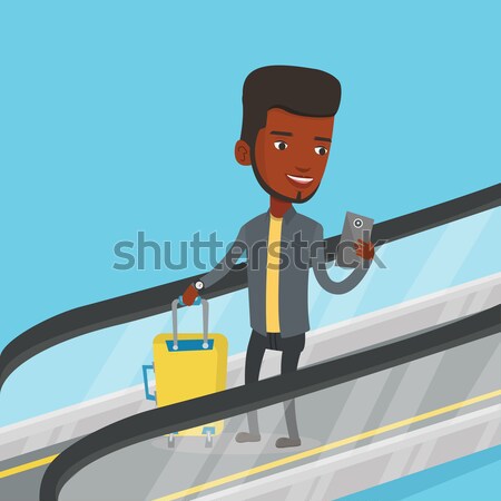 Man using smartphone on escalator in airport. Stock photo © RAStudio