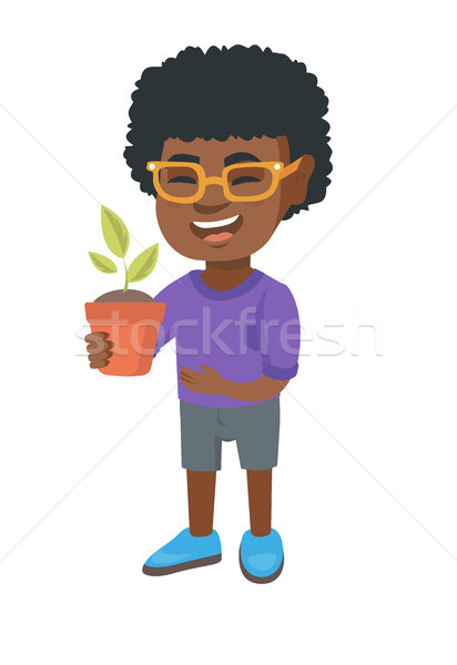 African smiling boy holding a potted plant. Stock photo © RAStudio