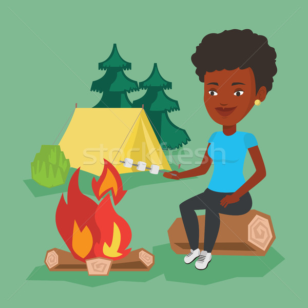Woman roasting marshmallow over campfire. Stock photo © RAStudio
