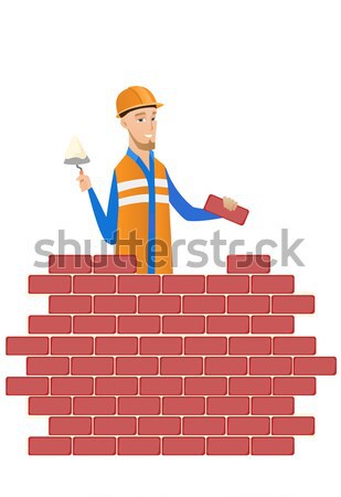 Young bricklayer working with spatula and brick. Stock photo © RAStudio