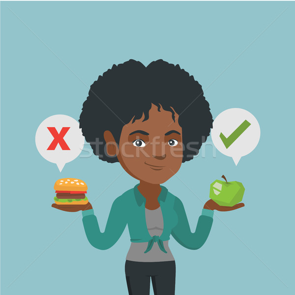Woman choosing between hamburger and cupcake. Stock photo © RAStudio
