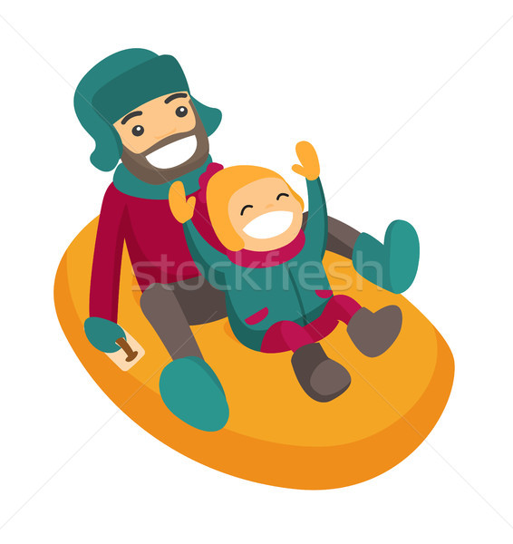 Father with son sledding down on snow rubber tube. Stock photo © RAStudio