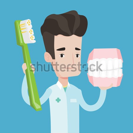 Dentist with dental jaw model and toothbrush. Stock photo © RAStudio