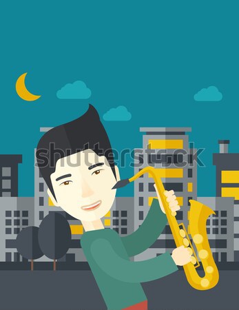 Saxophonist playing in the streets at night Stock photo © RAStudio