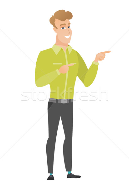 Young caucasian businessman pointing to the side. Stock photo © RAStudio