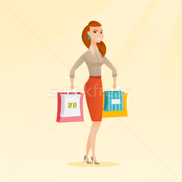 Stock photo: Young happy caucasian woman with shopping bags.