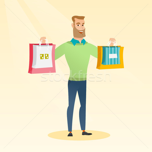 Young caucasian man holding shopping bags. Stock photo © RAStudio