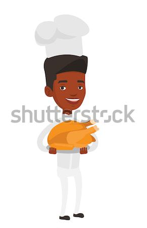 Chief cooker holding roasted chicken. Stock photo © RAStudio