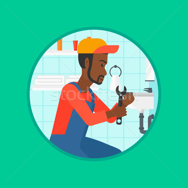 Plumber fixing sink pipe with wrench. Stock photo © RAStudio