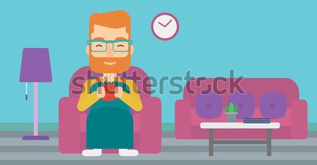 Man sitting in chair with cup of tea. Stock photo © RAStudio
