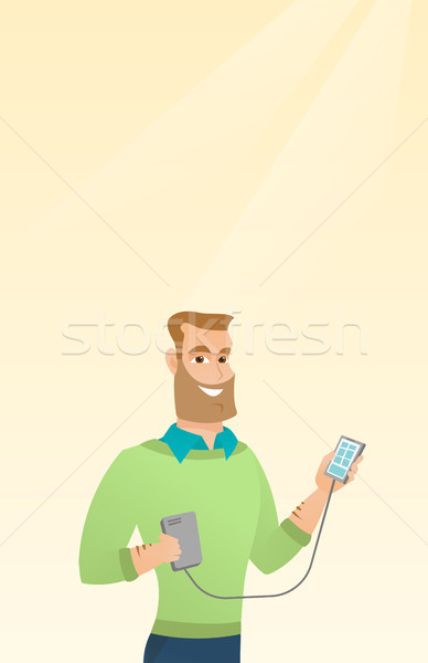 Man reharging smartphone from portable battery. Stock photo © RAStudio