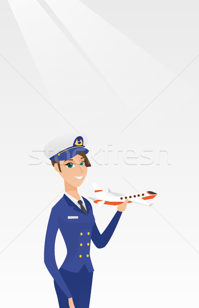 Cheerful airline pilot with the model of airplane. Stock photo © RAStudio