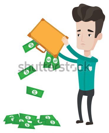 Stock photo: Businessman shaking out money from his briefcase.