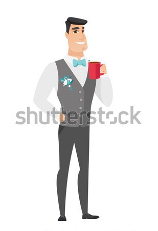 Young caucasian groom holding cup of coffee. Stock photo © RAStudio
