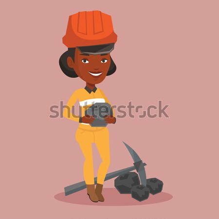 Young miner in hard hat holding a piece of coal. Stock photo © RAStudio