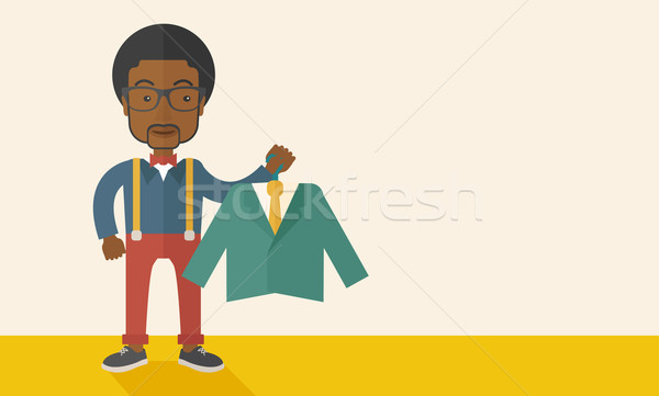 Stock photo: Happy young african man chooses a perfect clothe.