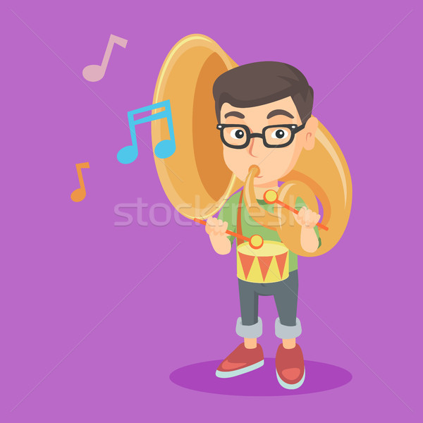 Stock photo: Caucasian kid playing the tuba and the drum.