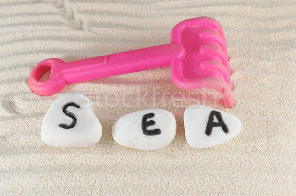 Stock photo: Sea word and rake