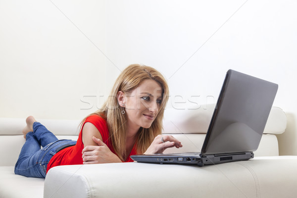 Femeie folosind laptop canapea fericit acasă Imagine de stoc © RazvanPhotography