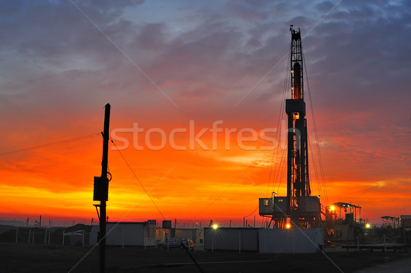 Puits de pétrole nuit construction coucher du soleil mer bleu Photo stock © razvanphotos