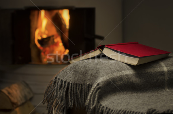 Stock photo: Open book by fireplace.